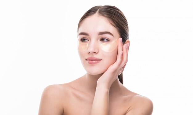 Hermosa mujer joven uso parche en piel fresca toque propio rostro. Tratamiento facial. Cosmetología.