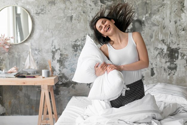 Hermosa mujer jugando con almohada