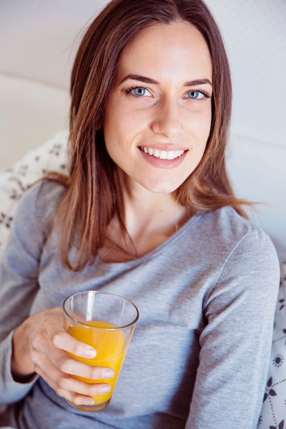 Foto gratuita hermosa mujer con jugo en la cama