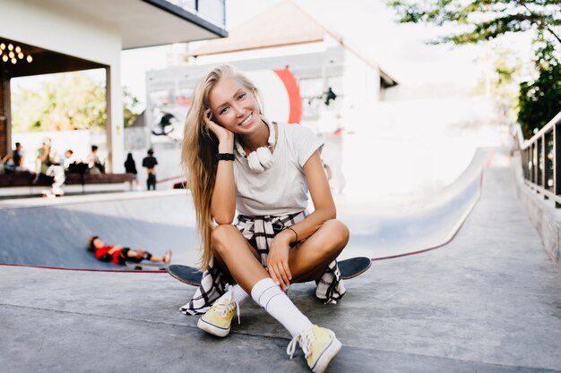 Hermosa mujer en lindos calcetines blancos posando con patineta.