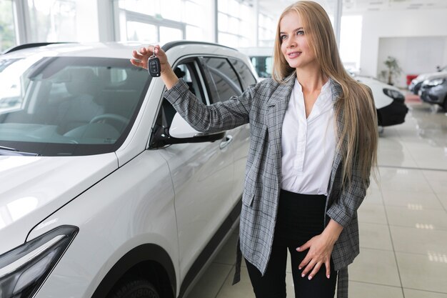 Hermosa mujer con las llaves del auto mirando a otro lado