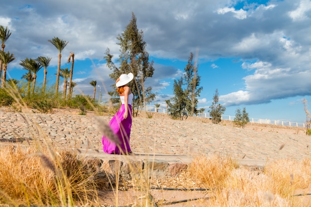 Hermosa mujer llevaba sombrero y falda de color rosa