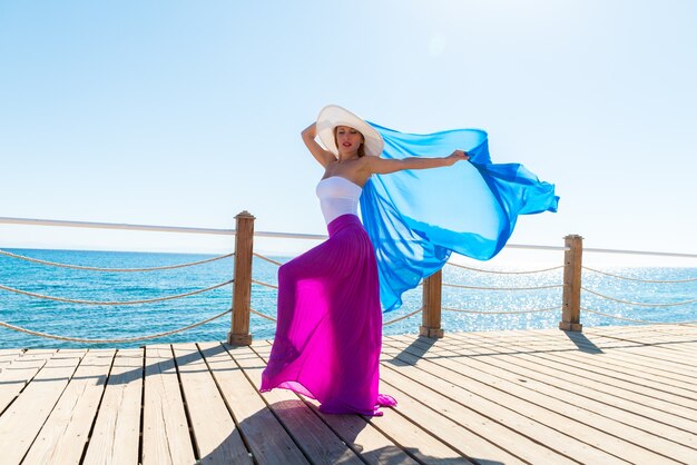 Hermosa mujer llevaba sombrero y falda de color rosa