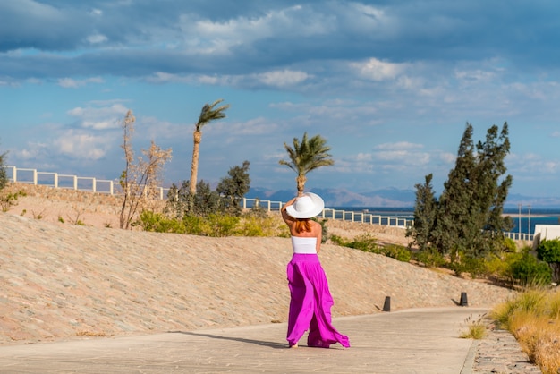 Hermosa mujer llevaba sombrero y falda de color rosa