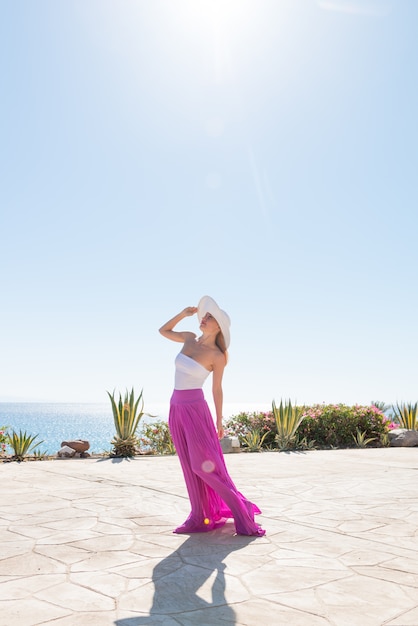 Hermosa mujer llevaba sombrero y falda de color rosa