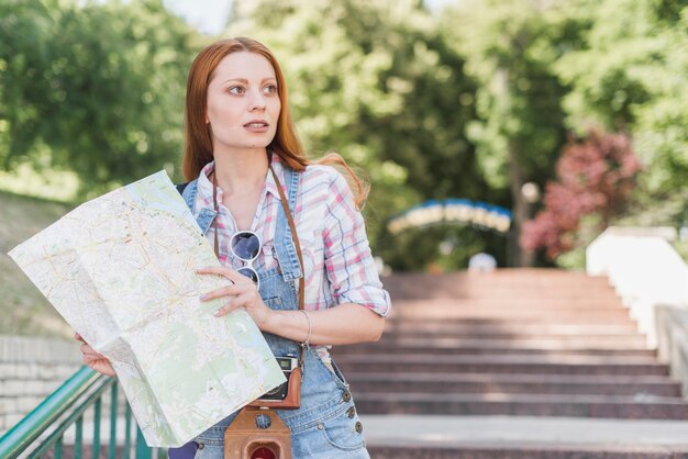 Hermosa mujer con mapa en el parque