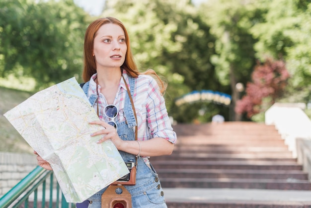 Hermosa mujer con mapa en el parque