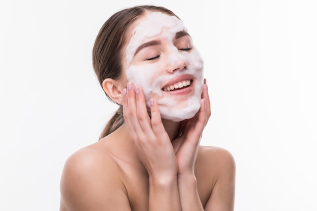 Hermosa mujer con máscara facial en la pared blanca. Cosméticos, cuidado de la piel.