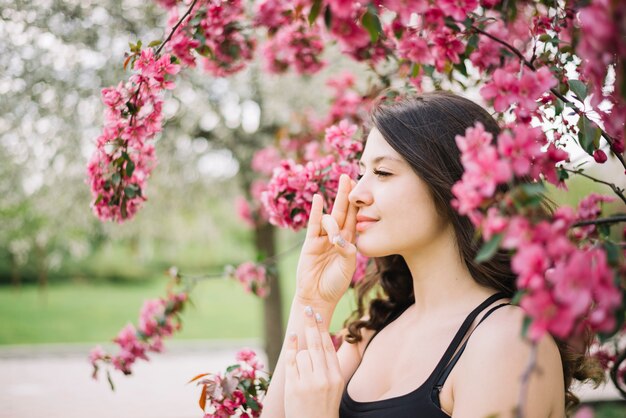 Hermosa mujer meditación con gesto mudra cerca del árbol en el jardín