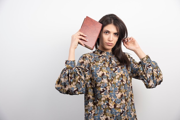 Hermosa mujer mirando a cámara con libro.