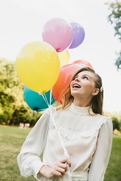 Hermosa mujer mirando globos