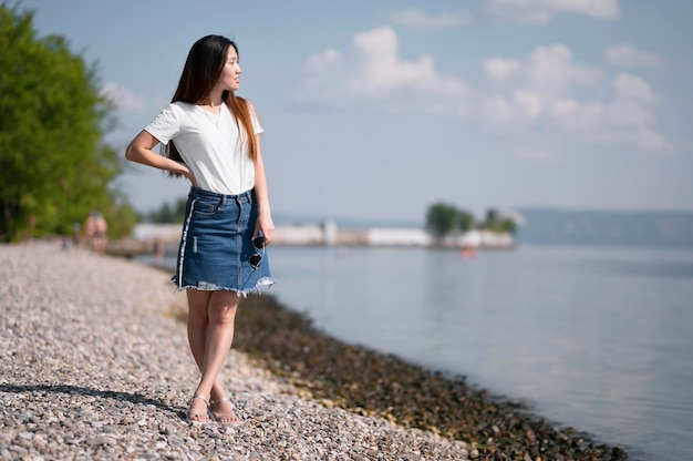 Hermosa mujer mirando a otro lado en la playa con espacio de copia