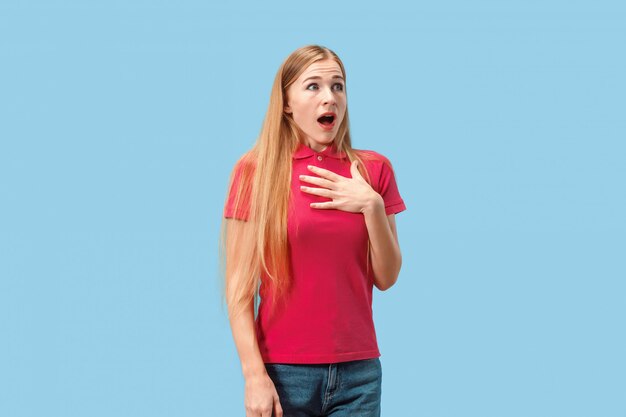 Hermosa mujer mirando sorprendido aislado en azul