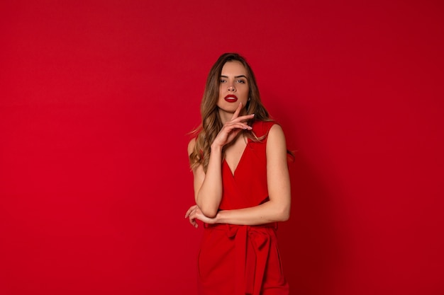 Hermosa mujer de moda en vestido rojo posando