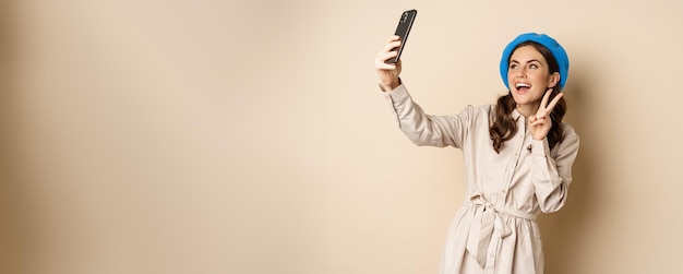 Hermosa mujer moderna posando para selfie con teléfono inteligente tomando fotos en el teléfono móvil sta