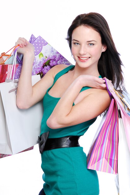 Hermosa mujer morena con bolsas de la compra - aislado en blanco