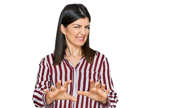 Hermosa mujer morena con camisa a rayas expresión disgustada, disgustada y temerosa haciendo cara de asco debido a la reacción de aversión. con las manos levantadas