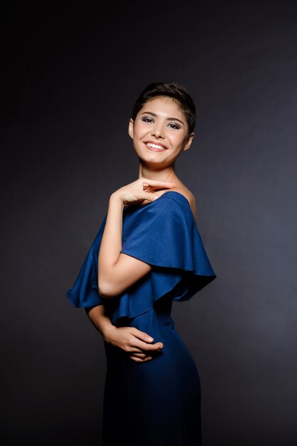 Hermosa mujer morena en vestido de noche sonriendo