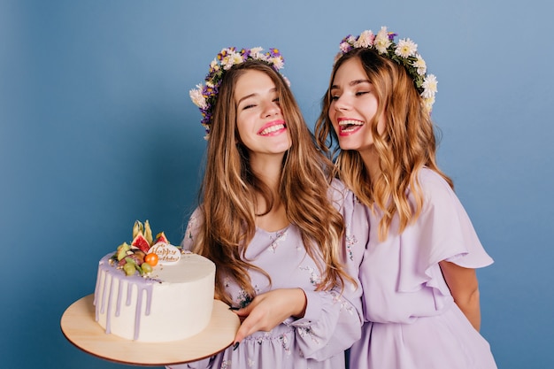 Hermosa mujer morena en vestido púrpura con pastel de cumpleaños