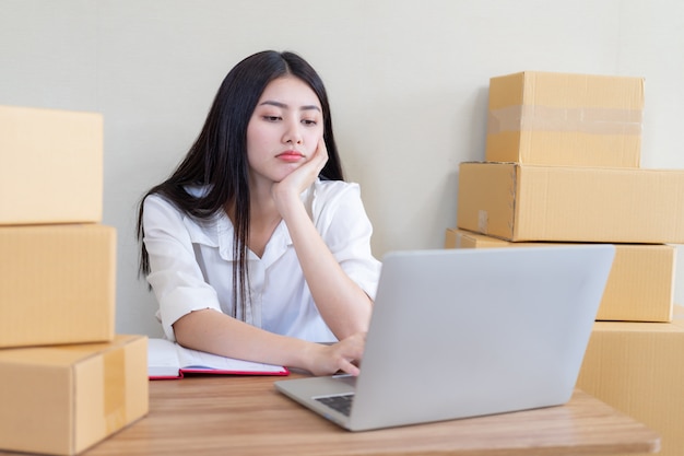 Hermosa mujer de negocios asiática joven cayó feliz después de recibir el correo electrónico producto de pedido