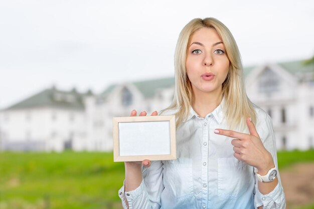 Hermosa mujer de negocios rubia apuntando al espacio de la copia