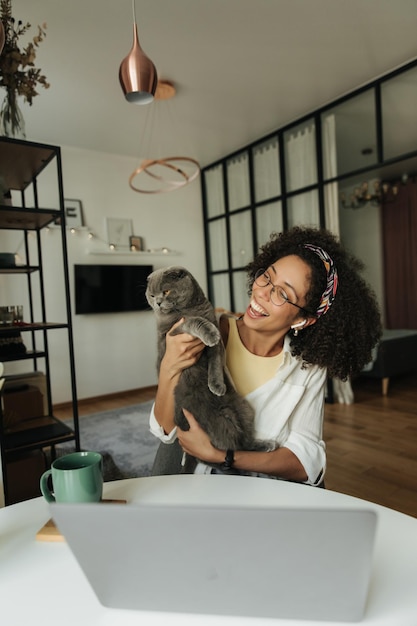 Foto gratuita hermosa mujer negra mostrando y mirando a su gato