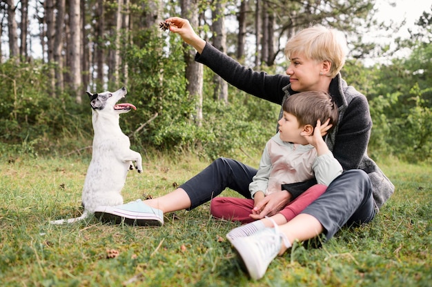 Hermosa mujer y niño jugando con perro