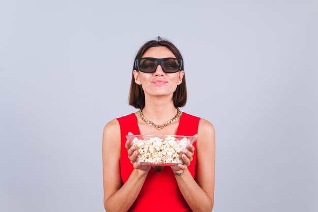 Hermosa mujer en la pared gris en gafas de cine 3d con palomitas de maíz, alegres emociones positivas felices