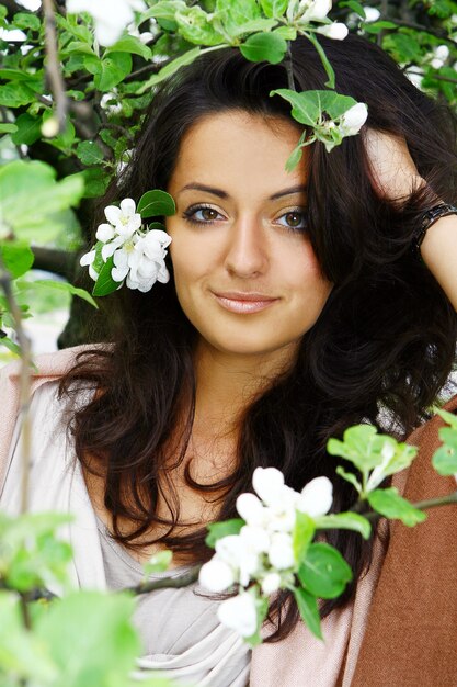 Hermosa mujer de pie por árbol floreciente