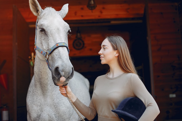 Hermosa mujer de pie con un caballo