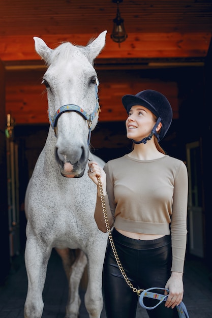 Foto gratuita hermosa mujer de pie con un caballo