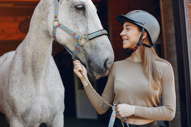 Hermosa mujer de pie con un caballo