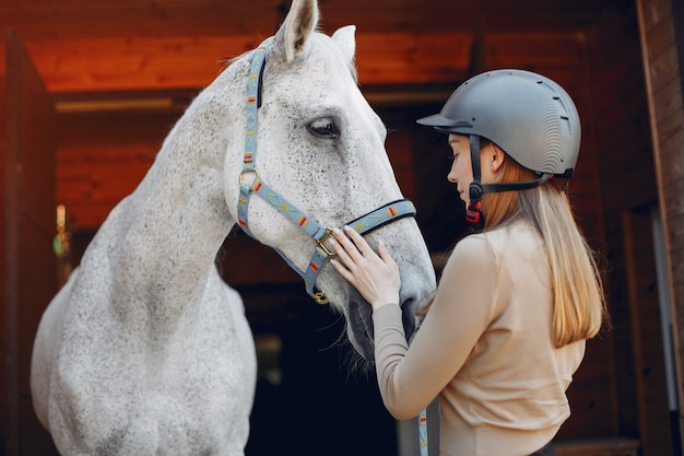 Hermosa mujer de pie con un caballo