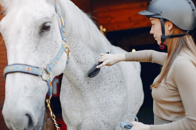 Hermosa mujer de pie con un caballo