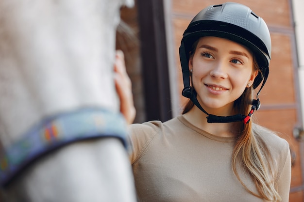 Foto gratuita hermosa mujer de pie con un caballo