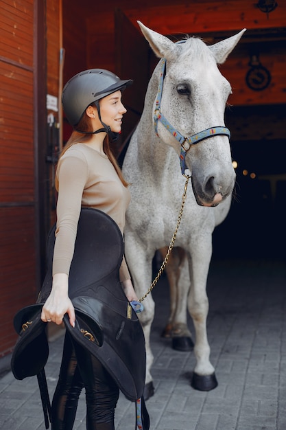 Foto gratuita hermosa mujer de pie con un caballo