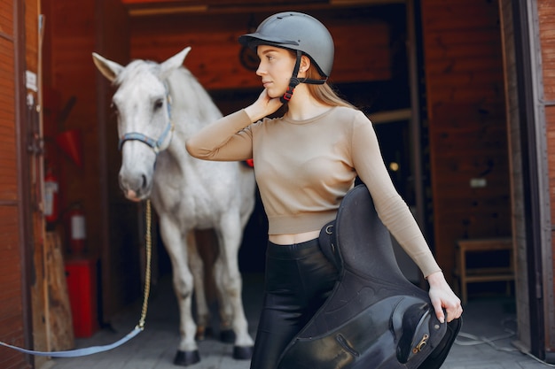 Hermosa mujer de pie con un caballo