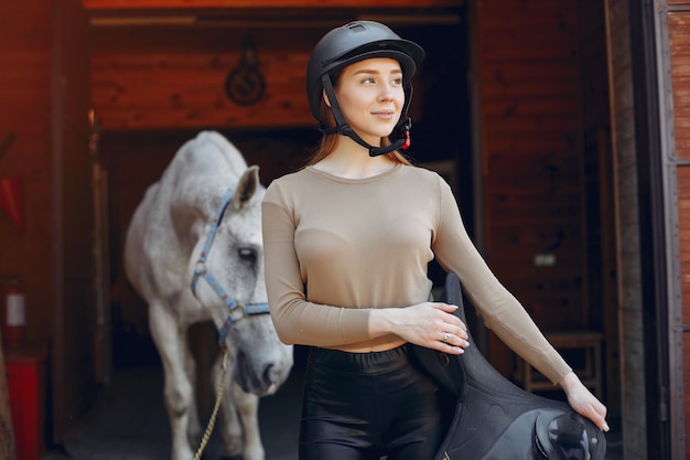 Hermosa mujer de pie con un caballo