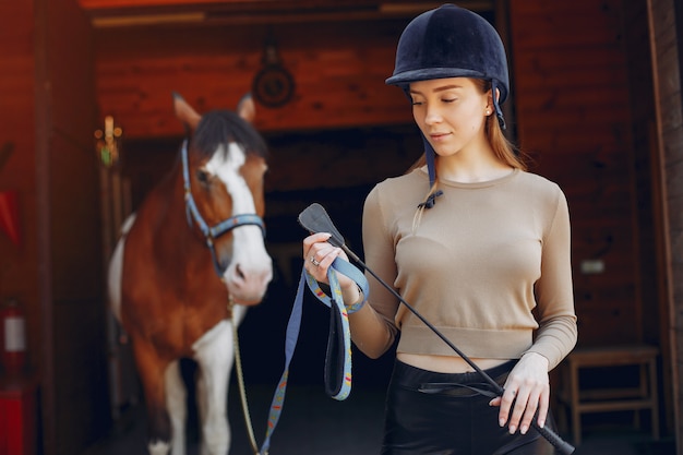 Foto gratuita hermosa mujer de pie con un caballo