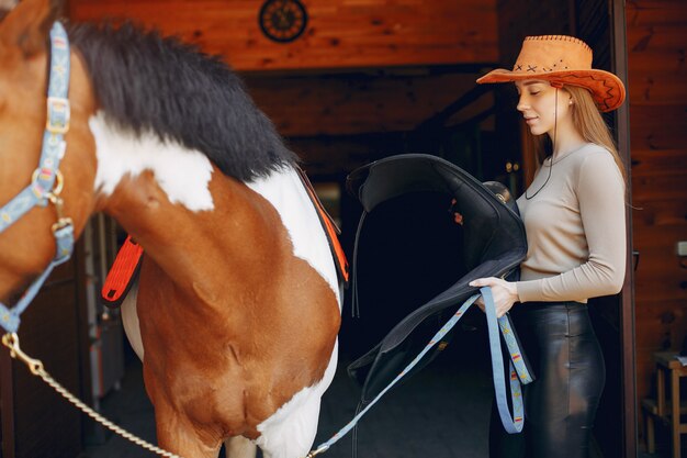 Hermosa mujer de pie con un caballo