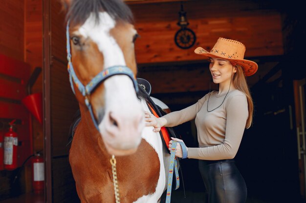 Hermosa mujer de pie con un caballo