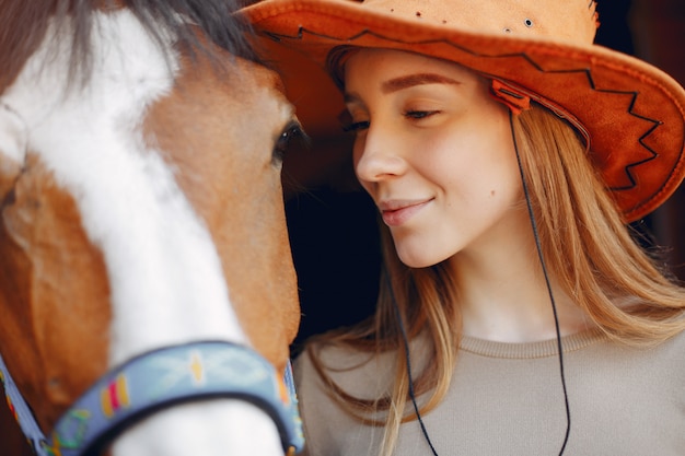 Hermosa mujer de pie con un caballo