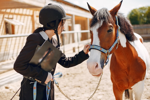 Hermosa mujer de pie con un caballo