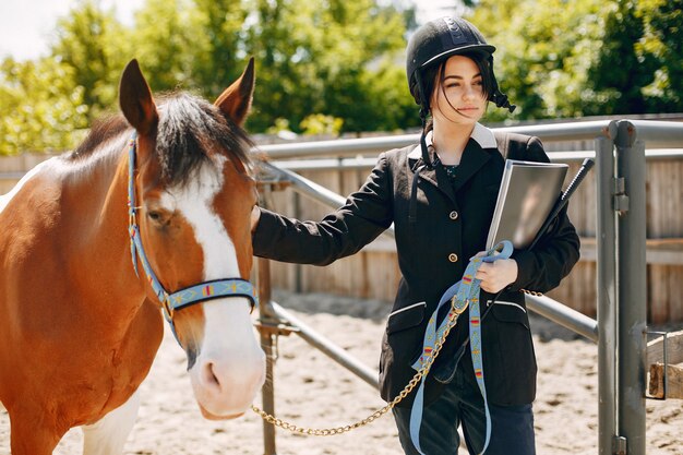 Hermosa mujer de pie con un caballo