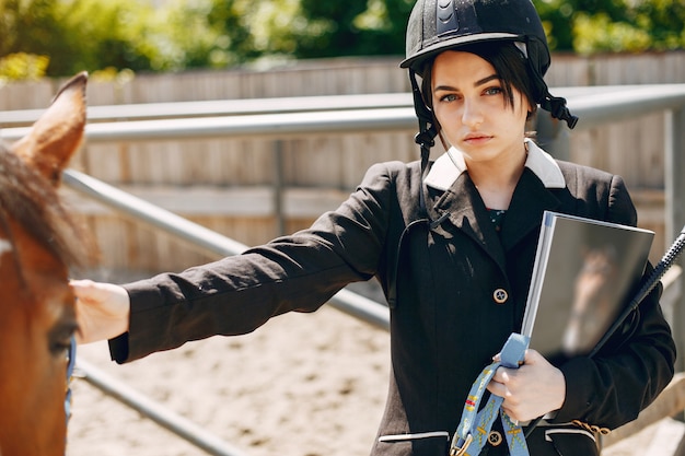 Hermosa mujer de pie con un caballo