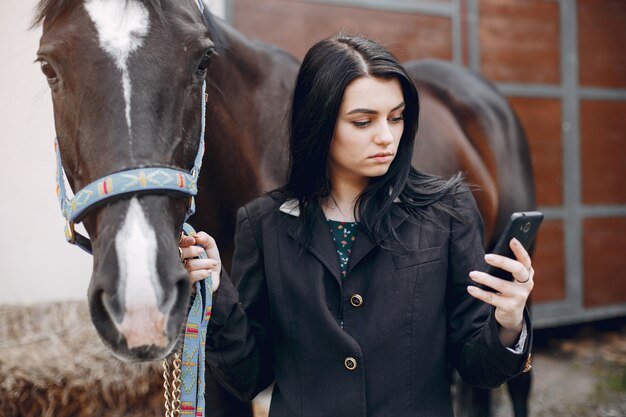 Hermosa mujer de pie con un caballo