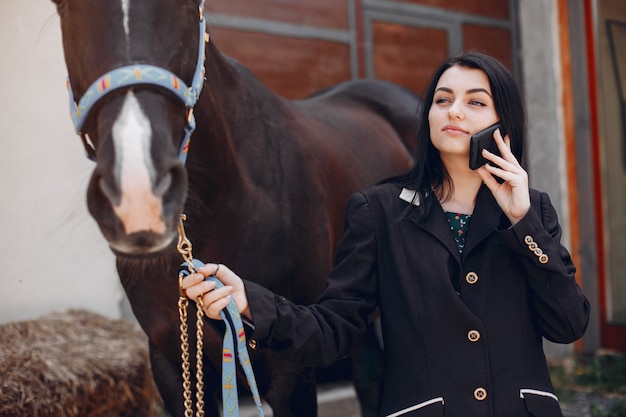 Hermosa mujer de pie con un caballo