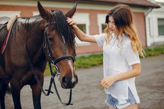 Hermosa mujer de pie con un caballo