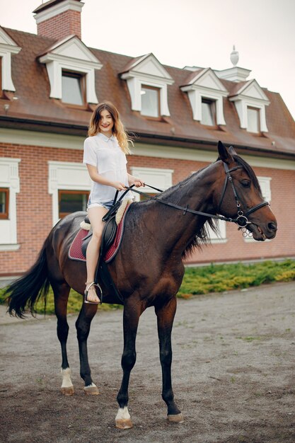 Hermosa mujer de pie con un caballo