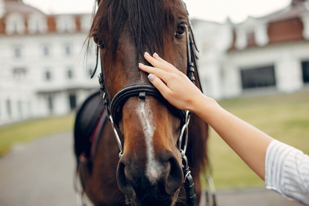 Hermosa mujer de pie con un caballo